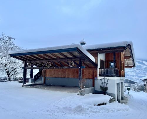 a building with snow on the ground in front of it at Stöcklgut Ferienhaus in Niedernsill