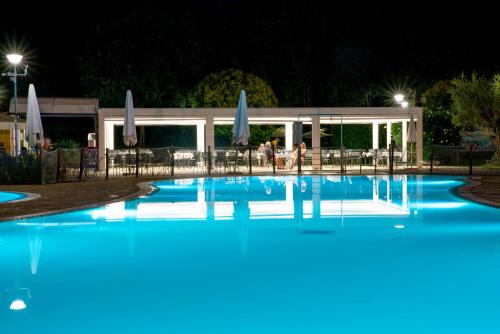 a large swimming pool at night with people in the background at Camping Baia Verde in Manerba del Garda