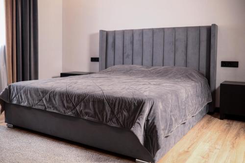 a bedroom with a large bed with a gray headboard at Dacha in Astana