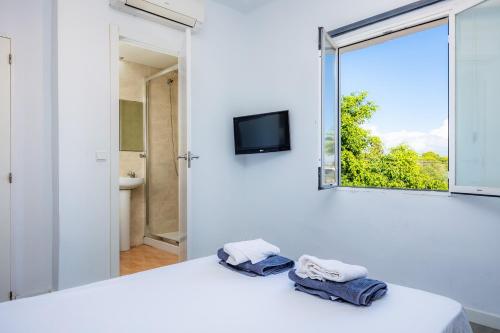 坎帕斯蒂利亚Mallorca Rooms Can Pastilla的一间白色的房间，里面有一张床，床上放着毛巾