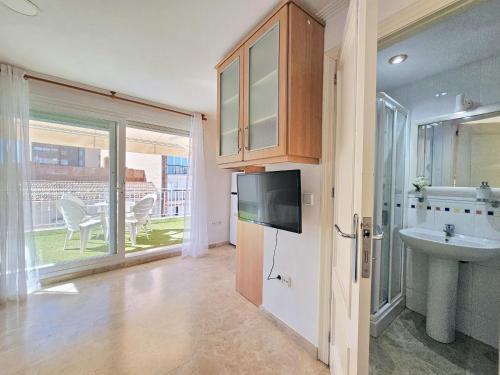 a bathroom with a sink and a tv and a sink at Atico A Cartagena centro historico Parking in Cartagena