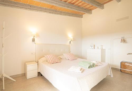 a white bedroom with a bed with two pillows at Apartamento Son Calo B by Rentallorca in Petra