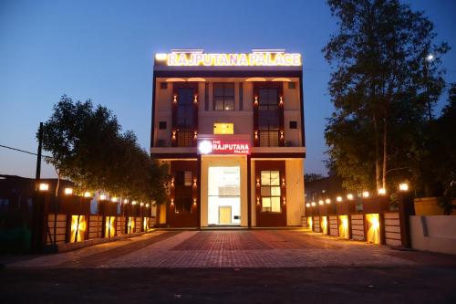 a building with a sign on top of it at night at The Rajputana Palace in Phanda