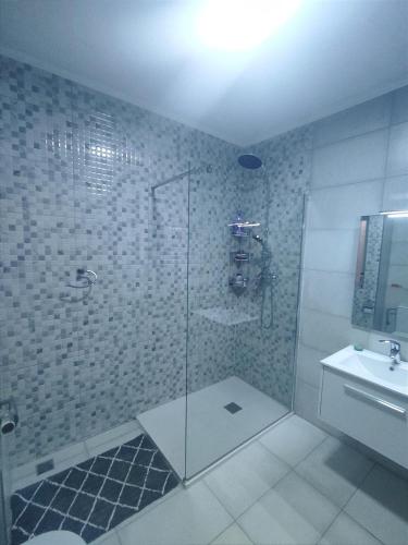 a bathroom with a glass shower and a sink at Swieqi 3 bedroom apartment in St. Julianʼs