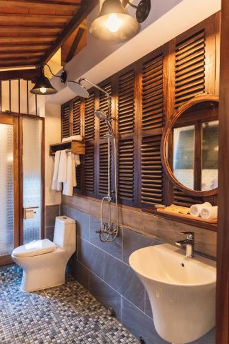 a bathroom with a sink and a toilet and a mirror at Gahi Homestay in Hue