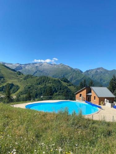 une grande piscine bleue en face d'une montagne dans l'établissement Duplex au cœur de la station, à Ustou