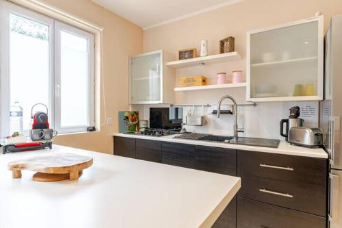 a kitchen with a white counter top and a sink at Maison au bout du chemin in Gouvieux
