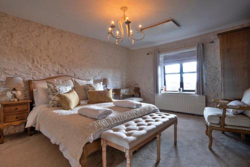une chambre avec un grand lit et un lustre dans l'établissement Finest Retreats - The Cottages Collection, à Buxton