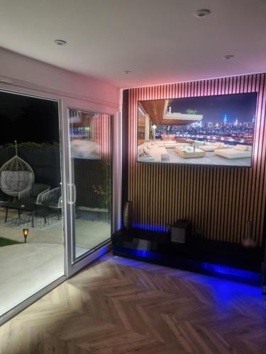 a living room with a large tv on the wall at Estwood - Gated House in Southampton