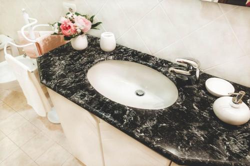 a bathroom sink with a black marble counter top at Casa La Lilla in Cascina