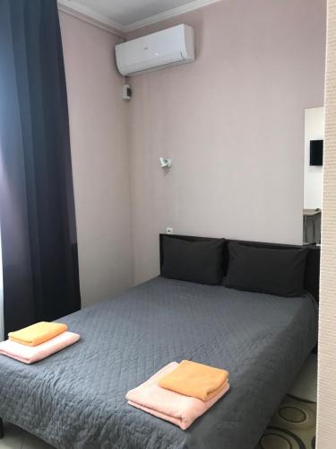 a bedroom with a bed with two towels on it at Karavella in Mykolaiv