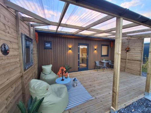 a wooden patio with a pergola and a table at Pond residence Pine 2ppl Adults only in Rathdowney