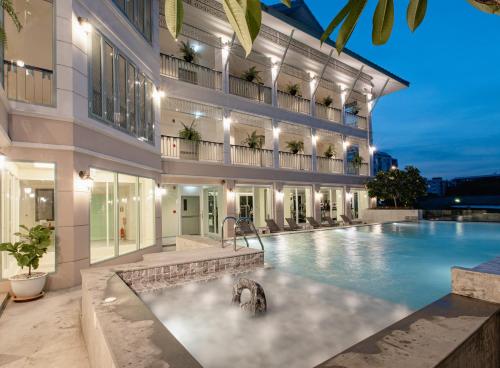 a swimming pool in front of a building at Siam Tharadol in Bangkok
