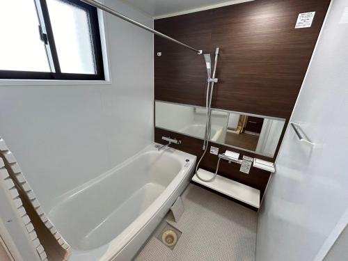 a bathroom with a bath tub and a toilet at nico chan house in Chatan