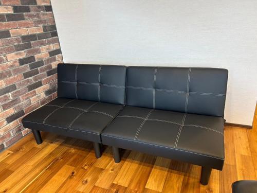 a black bench in front of a brick wall at nico chan house in Chatan