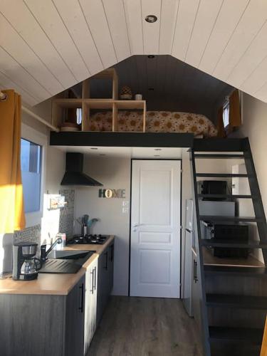 - une petite cuisine avec un lit dans une petite maison dans l'établissement Aux arômes de Mich, à Coulogne