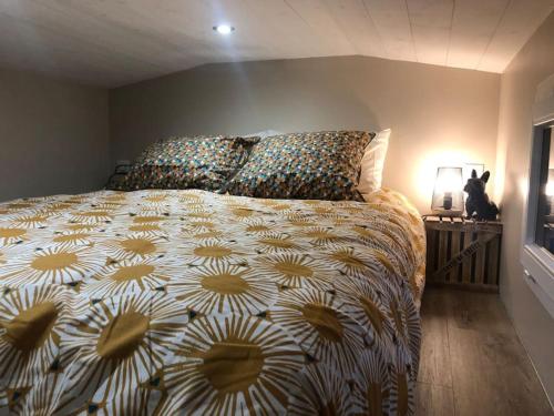 - une chambre avec un lit et un chat assis sur une table dans l'établissement Aux arômes de Mich, à Coulogne