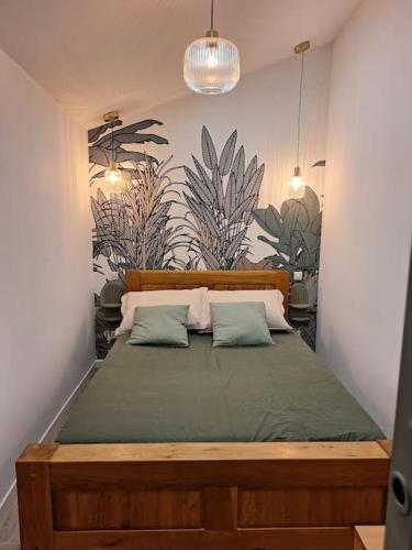 une chambre avec un grand lit avec deux oreillers dans l'établissement Charmante maisonnette équipée, à Caudebec-lès-Elbeuf