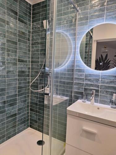 une salle de bain avec une douche en verre et un lavabo dans l'établissement Charmante maisonnette équipée, à Caudebec-lès-Elbeuf