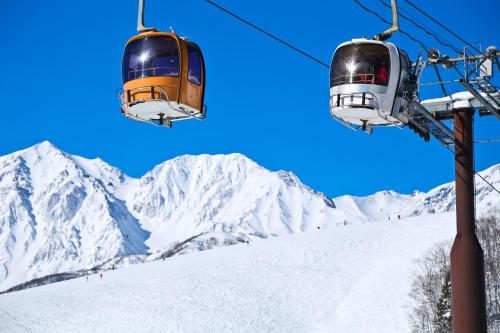 two ski lifts flying over a snow covered mountain at Holiday Inn Resort Shinano-Omachi Kuroyon by IHG in Omachi
