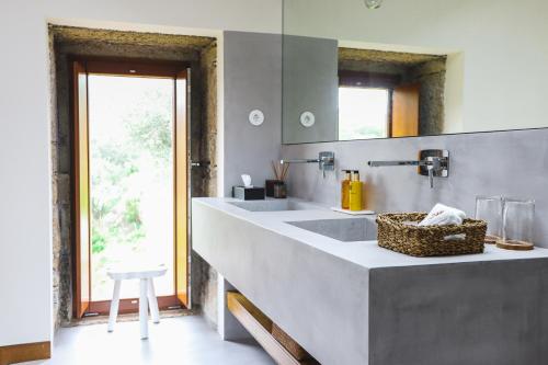 a bathroom with two sinks and a mirror at Casas da Vinha - Vineadouro Wine Hotel in Numão