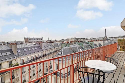 un balcon avec deux chaises et une vue sur une ville dans l'établissement Penthouse Champs Élysées, vue sur tout Paris et la Tour Eiffel, à Paris
