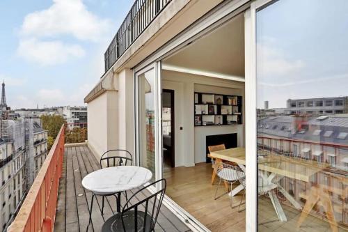 un balcon avec une table et des chaises sur un immeuble dans l'établissement Penthouse Champs Élysées, vue sur tout Paris et la Tour Eiffel, à Paris
