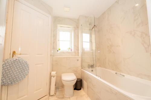 a bathroom with a toilet and a tub and a sink at Pristine Purfleet Newly Renovated 2Bed, 2Bath in Purfleet