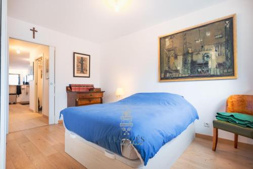 - une chambre dotée d'un lit bleu et d'une peinture murale dans l'établissement Le 103, appartement au cœur de la ville du Touquet, à Le Touquet-Paris-Plage