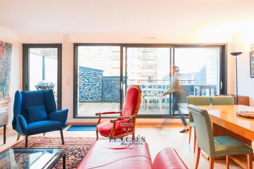 - un salon avec des chaises, une table et une personne dans l'établissement Le 103, appartement au cœur de la ville du Touquet, à Le Touquet-Paris-Plage