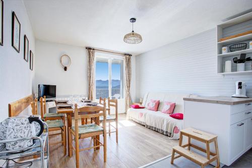 une cuisine et un salon avec une table et un canapé dans l'établissement EdenWeiss - Appt 6p à 1km des pistes, aux Angles