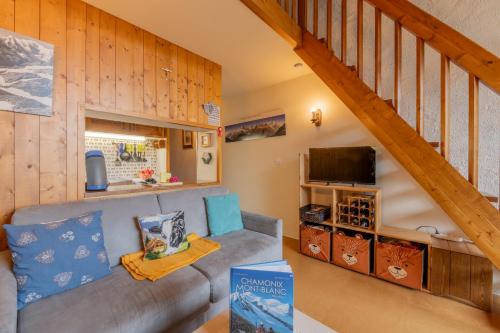 un salon avec un canapé et un escalier dans l'établissement Rafforts E8 - Happy Rentals, à Chamonix-Mont-Blanc