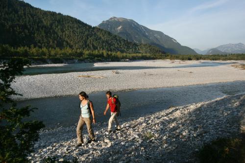 two people walking on the rocks near a river at Landgasthof Kaiserkrone in Elmen