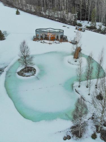 an aerial view of a frozen pond in the snow at Dabas Osta in Jūdaži