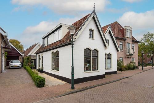 a white building on a street with houses at The White Cottage in Uitgeest