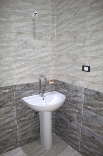 a bathroom with a white sink in a room at AL Farida Guest House in Jazīrat al ‘Awwāmīyah