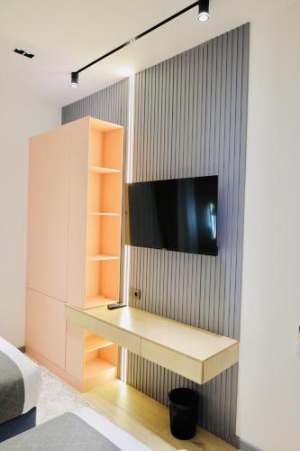 a bedroom with a desk with a tv on a wall at RIO Hotel in Samarkand