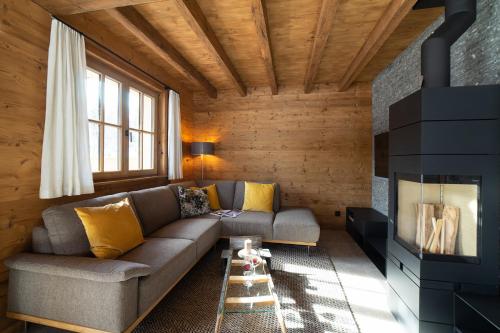 a living room with a couch and a fireplace at Chalet Schafberg in Wildhaus