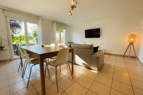 une salle à manger avec une table, des chaises et un canapé dans l'établissement Beautiful renovated house in a residential area, à Véretz