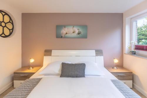 a bedroom with a white bed and two lamps at Carpe Diem in Husum