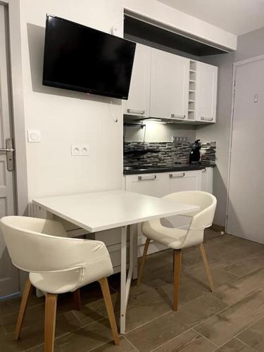 une cuisine avec une table blanche et deux chaises blanches dans l'établissement Eden urbain au centre ville, à Chalon-sur-Saône