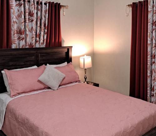 una camera da letto con un grande letto con tende rosse di Tropix Getaway - Rental Car Available a Crocus Hill