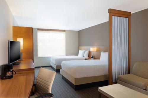 a hotel room with two beds and a television at Courtyard by Marriott Ciudad del Carmen Campeche in Ciudad del Carmen