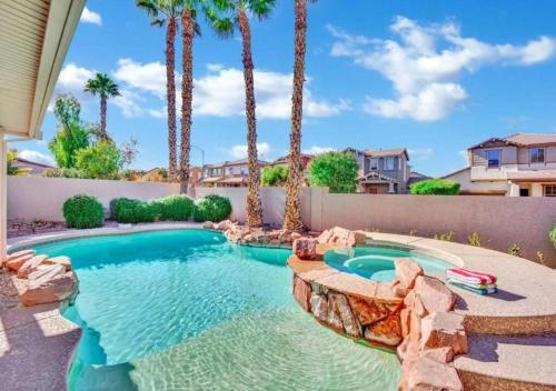 a swimming pool with palm trees in a yard at Seven Palms in Henderson