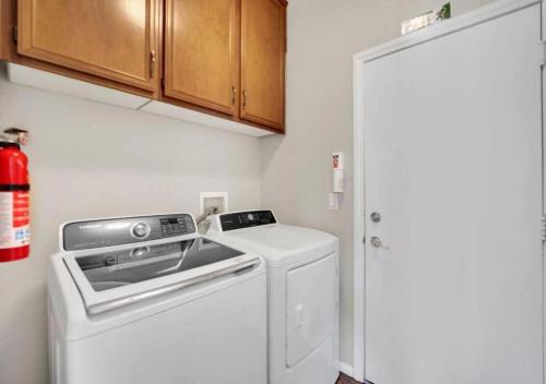 a small kitchen with a stove and a washer at Seven Palms in Henderson
