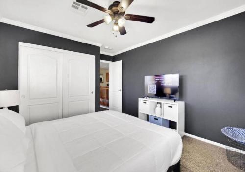 a bedroom with a white bed and a ceiling fan at Seven Palms in Henderson