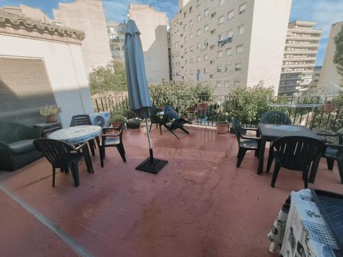 a patio with tables and chairs and an umbrella at La Posada de San Marcial in Tudela