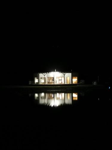 a house lit up at night in the dark at Dabas Osta in Jūdaži