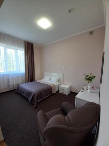 a hotel room with a bed and a couch at Karavella in Mykolaiv