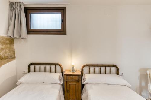 two twin beds in a room with a window at La Cabanya de La Rovira in Joanetes